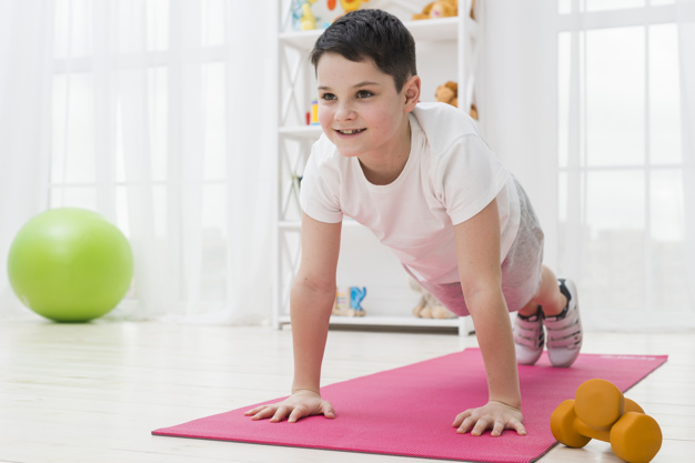 menina na colchonete realizando exercício de pilates para crianças