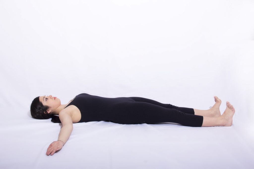 mulher deitada no chão realizando exercicio de respiração