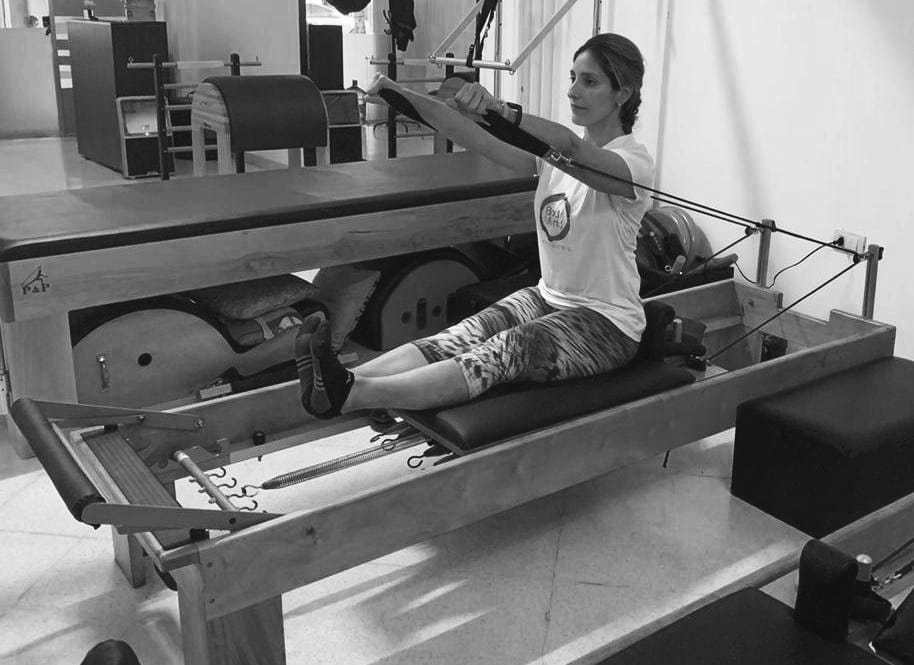 mulher realizando exercicio rowing 3 no reformer de pilates