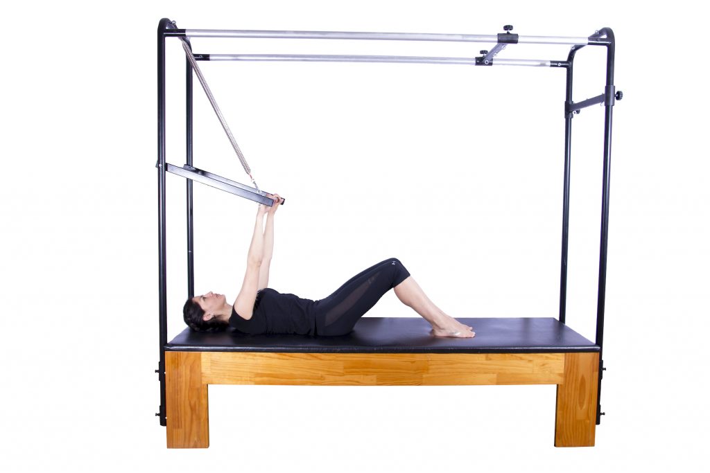 mulher deitada no cadillac de pilates
