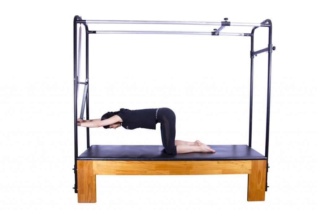 mulher realizando exercício no cadillac pilates