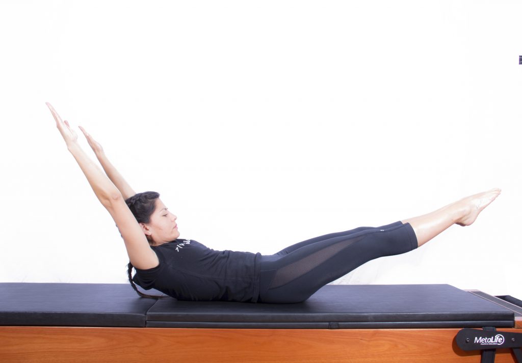Mulher realizando exercício de pilates double leg stretch 2