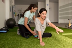 Fisioterapeuta tratando patologias da aluna com pilates