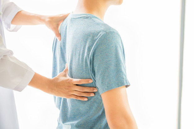 Profissional fisioterapeuta analizando a coluna