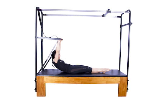 exercício sit up de pilates no cadillac