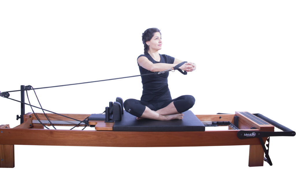 Mulher fazendo exercício em pilates reformer.